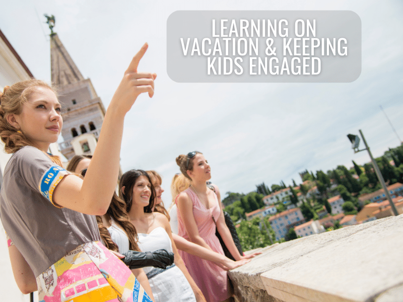 Teens learning on vacation as they observe the area around them. One girl is pointing to something outside the picture.