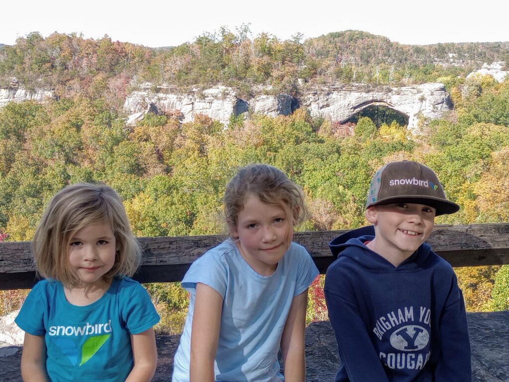 My three kids with Natural Arch behind them in the distance