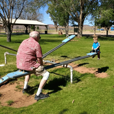 My dad and son playing on a seesaw at a playground