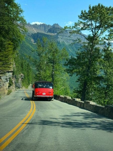 Vintage Red bus tour driving on Going-to-the-Sun Road in Glacier National Park