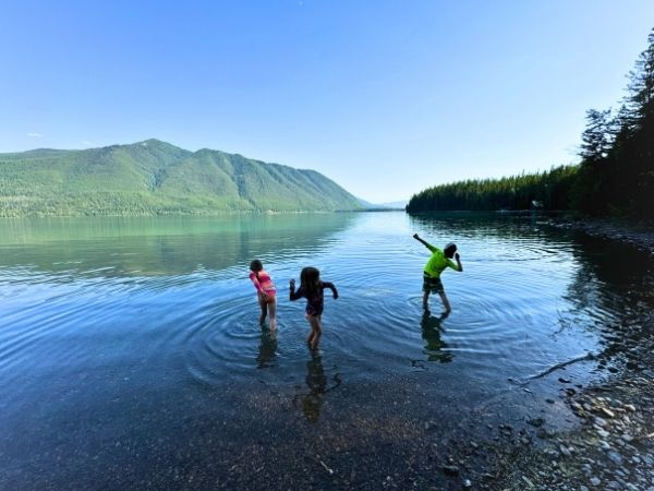 My three kids throwing rocks at Lake McDonald in Glacier National Park